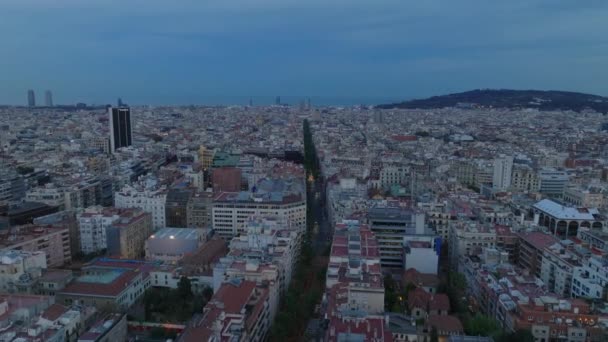 夕暮れ時の大都市の空中パノラマビュー 都市部のバラの密な町の開発を通過広い直線道路 スペインのバルセロナ — ストック動画