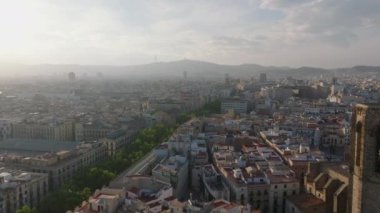 Tarihi şehir merkezinin üzerinden uç. Altın saatinde gün ışığına karşı puslu bir manzara. Tepedeki TV kulesinin silueti. Barselona, İspanya.
