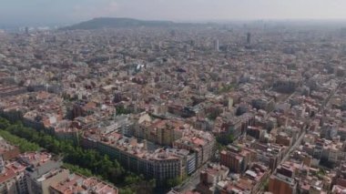Metropolis 'teki şehir gelişiminin hava panoramik görüntüsü. Şehir merkezindeki binaların üzerinden uçmak, güneş ışığına karşı puslu bir manzara. Barselona, İspanya.