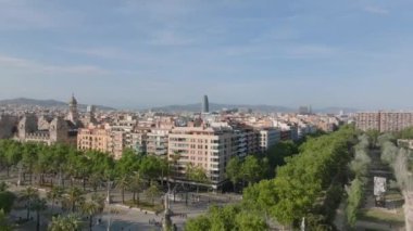 İleri, şehrin üzerinde uçar. Şehir merkezinde palmiye ağaçları ve apartman binaları var. Barselona, İspanya.