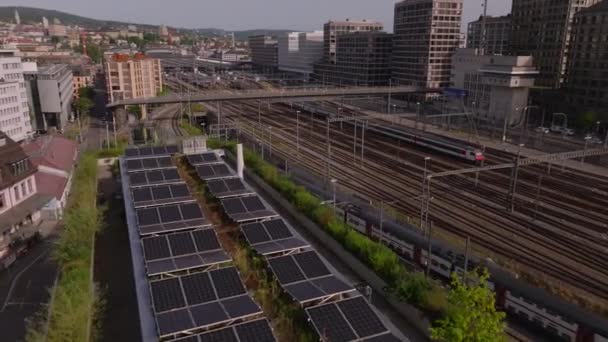 通勤列车接近地下铁路车站的航拍 城市的铁路基础设施 太阳能电池在房顶上生产可持续能源 瑞士苏黎世 — 图库视频影像