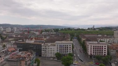 Bulutlu bir günde şehirdeki çeşitli binaların üzerinden uç. Sokaklar boyunca çok katlı apartmanlar. Zürih, İsviçre.