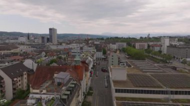 Bulutlu bir günde şehir merkezindeki cadde ve binaların hava manzarası. Yüklü güneş pilleriyle çatıda uçun. Zürih, İsviçre.