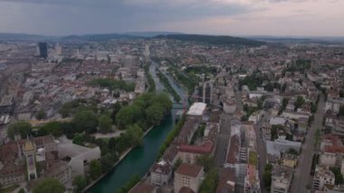 Bulutlu bir günde şehrin havadan panoramik görüntüsü. Nehrin üzerinden şehir ilçelerine doğru ilerliyorlar. Zürih, İsviçre.