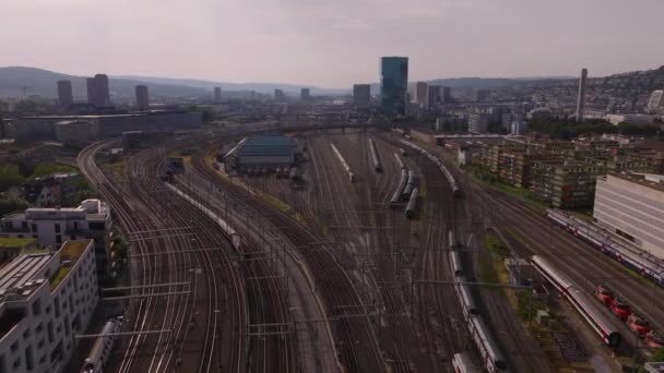 前进方向在有许多轨道和交换器的铁路大院落上方飞行 火车穿过城市 瑞士苏黎世 — 图库视频影像