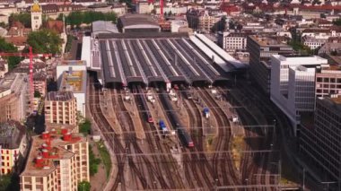 Güneşli bir günde Hauptbahnhof 'un hava görüntüleri. Çatı platformları, çeşitli yolcu trenleri ve şehirdeki binalar. Zürih, İsviçre.