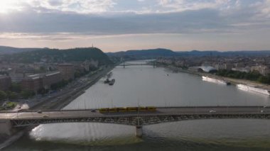 Tuna nehri boyunca uzanan köprünün üzerinden ileriye doğru uçuyor. Gün batımında Metropolis 'in havadan panoramik görüntüsü. Budapeşte, Macaristan.