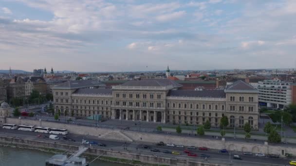 その後 コルヴィナス大学の建物の複合体の上を飛行します トワイライトのウォーターフロントにある歴史的な宮殿 ブダペスト ハンガリー — ストック動画