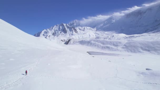 空中飞越独行的雄性远足者在提利科湖小径雪地的小径上穿越高山湖 马南区Annapurna步行线路 探索尼泊尔喜马拉雅山 — 图库视频影像