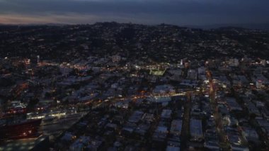 Gece, kentsel çevredeki işlek caddelerin ve binaların havadan yükselen görüntüsü. Los Angeles, Kaliforniya, ABD