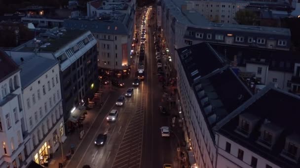 在城市的夜晚大街上 前进方向在成排的汽车和电车之上飞行 在电车轨道上行驶的车辆 德国柏林 — 图库视频影像