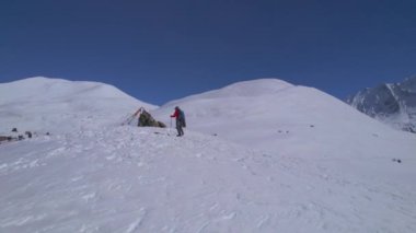 Yürüyüş yolunda yükselen beyaz erkek doğa yürüyüşçüsü sırıkla Himalayalar 'daki Tilicho bakış açısına gider. Annapurna çevre yürüyüşü. Maceracı yalnız başına Himalaya dağlarını keşfeder.