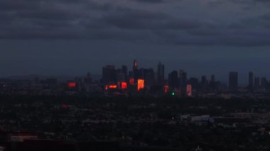 Şehir merkezindeki gökdelenlerin akşam görüntüleri gün batımında turuncu güneş ışığını yansıtıyor. Los Angeles, Kaliforniya, ABD