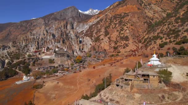エアリアル後方パノラマの寺院とテマラ村の家屋の集落 アナプナーサーキットトレッキング ヒマラヤ山脈は古い村々からなる ネパール マナン — ストック動画
