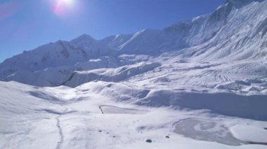 Yüksek Himalayalar 'daki Tilicho Gölü' ne giden bir grup yürüyüşçünün hava görüntüsü. Yürüyüş macerası, karlı Nepal dağları konseptinde tur grupları.