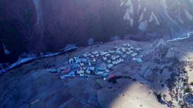 Dağ vadisindeki Khangshar köyündeki evlerin üzerinde uçan dairesel hava manzarası. Manang bölgesi. Tilicho ana kamp yolu. Himalayalar dağları. Himalayalarda Turizm ve Seyahat