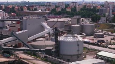 Büyük silindirik depolama kapasitesi. Limanın lojistik kısmı. Arka planda şehir merkezindeki çok katlı apartmanlar. Stockholm, İsveç.