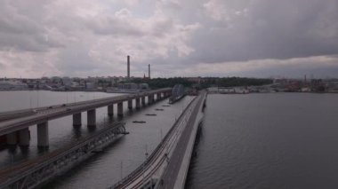 İleri, Lidingobron köprülerinin üzerinden uçar. Yeni tramvay, ayak ve bisiklet köprüsü eski köprünün yanında. Stockholm, İsveç.