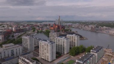 Rıhtımdaki çok katlı apartmanın havadan görünüşü. Karşı kıyıda ısıtma fabrikası ve kömür yığını. Helsinki, Finlandiya.