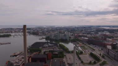İleride ısıtma tesisi ve limandaki kömür deposu üzerinde uçacağız. Deniz kıyısındaki büyük şehrin panoramik manzarası. Helsinki, Finlandiya.