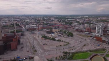 Şehrin havadan panoramik görüntüsü. Yerleşim yerlerindeki binalar. Eski sanayi bölgesinde tarihi bir gaz tutucusu ve bacası olan bir fabrika var. Helsinki, Finlandiya.