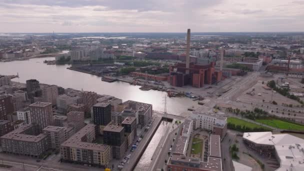 前方飞越城市住宅区的多层现代建筑 海滨有高高的烟囱的燃煤采暖厂 芬兰赫尔辛基 — 图库视频影像