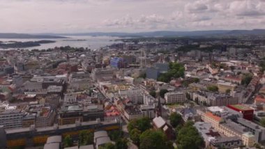 Şehirdeki binaların hava görüntüleri. Şehir merkezindeki kilise ve bloklar dolusu ev. Arka planda adalar olan bir su alanı. Oslo, Norveç.