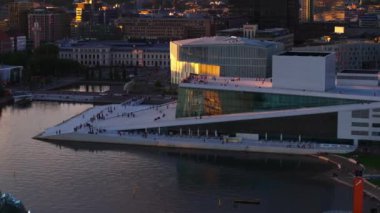 Günbatımında modern Oslo Opera Binası 'ndaki gezinti ve gözetleme platformunda yürüyen insanların hava görüntüsü. Oslo, Norveç.