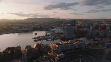 Gün batımında Manastır 'ın hava kaydırak ve pan görüntüleri. Rıhtımdaki Norveç Operası ve Balesi 'nin gelecekteki binası. Başkentteki modern binalar. Oslo, Norveç.