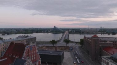 Eski kasabadaki tarihi binaların etrafında uçmak. Daugava nehri kıyısı ve Akmens yatık köprüsünü gözler önüne seriyor. Karşıdaki bankada modern tasarım Ulusal Kütüphane binası. Riga, Letonya.