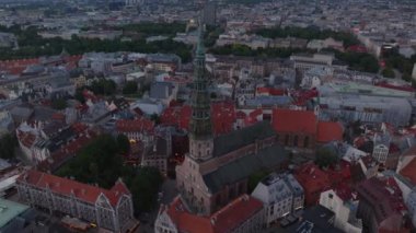 Alacakaranlıkta tarihi şehir merkezinin yüksek açılı görüntüsü. St. Peters Kilisesi 'nin etrafındaki eski binaların ve dar sokakların hava görüntüleri. Riga, Letonya.