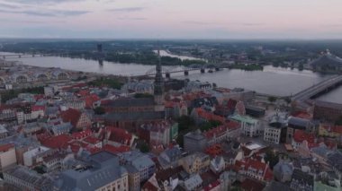 St. Peters Kilisesi ve Daugava nehri yakınlarındaki turistik manzaralı tarihi şehir merkezinin havadan panoramik manzarası. Karşıdaki bankada modern tasarım Ulusal Kütüphane binası. Riga, Letonya.