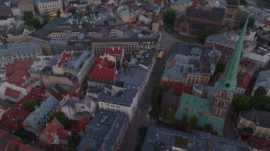 Eski kasabadaki caddelerin ve binaların yüksek açılı görüntüsü. Turistik yerler ve dar koridorlar. Hava kararınca şehir manzarasını ortaya çıkar. Riga, Letonya.