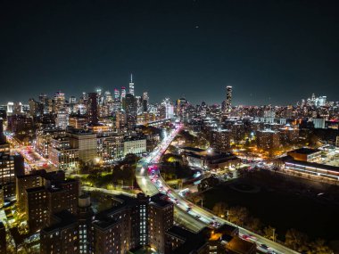 Gece panoramik çekimleri modern metropolün aydınlık gökdelenleri ve işlek otoyolları ile. New York City, ABD.