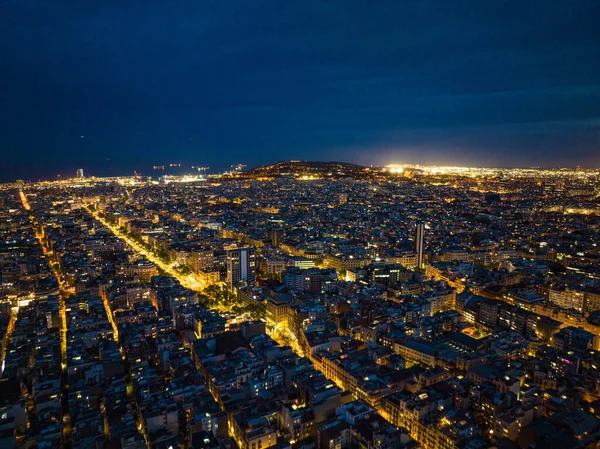Metropolis 'in gece manzarası. Aydınlatılmış sokakların ve büyük şehirlerdeki binaların havadan panoramik görüntüsü. Barselona, İspanya.