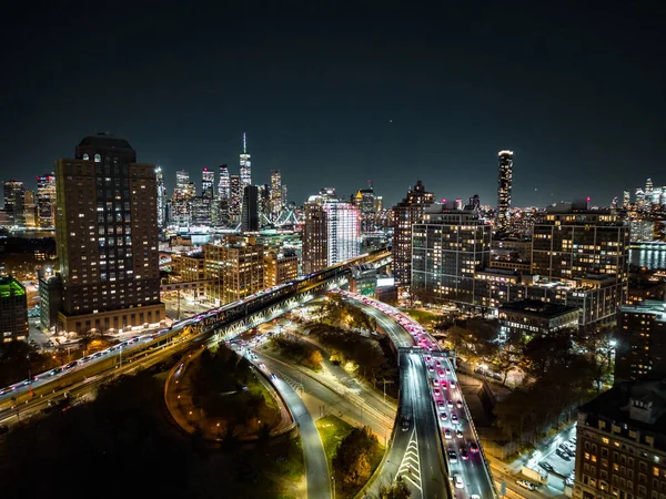 Metropolis 'in modern kentsel bölgesinde akşam yemeği. Parlayan yüksek binalar ve çok şeritli yollarda yoğun trafik. Renkli şehir ışıkları. New York City, ABD.