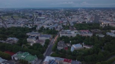 Alacakaranlıktaki büyük şehrin havadan görünüşü. Şehir merkezindeki çok şeritli ana yolda giden arabalar. Metropolis 'te büyük binalar ve saraylar. Riga, Letonya.