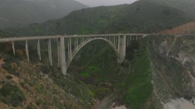 Yüksek kemerli köprü manzarası harika. Geriye doğru kayalık kıyıları ve dalgalı deniz dalgalarını ortaya çıkarıyor. Kaliforniya, ABD.