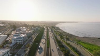 Şafakta deniz kıyısındaki işlek otoyolun havadan görüntüsü. Tropikal varış noktasında trafik vardı. Ventura, California, ABD.