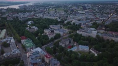 Şehirdeki büyük binaların havadan görüntüsü. Metropolis 'in alacakaranlıktaki düz manzarasının panoramik görüntüsü. Riga, Letonya.