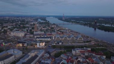 Gün batımında geniş Daugava nehrinin üzerinde uçun. Adada birkaç köprü, modern uzun radyo ve televizyon kulesi var. Riga, Letonya.