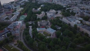 Yeşil parkı ve lüks sarayları olan şehir merkezinin üzerinde uçmak. Eğitim ve hükümet binaları gün batımında şehirde olacak. Riga, Letonya.