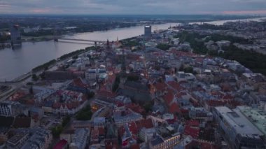 İleriye doğru hava karardığında tarihi şehir merkezinin üzerinde uçar. Turistik manzaralı, geniş Daugava nehri akan eski bir kasabanın havadan panoramik manzarası. Riga, Letonya.