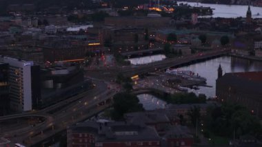 Akşam kentinde çok katlı bir kavşaktan geçen araçlar. Rıhtımın hava görüntüleri. Stockholm, İsveç.