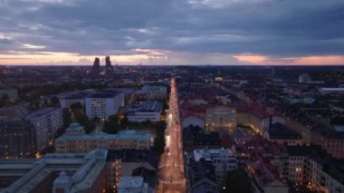 Alacakaranlıkta yerleşim yerinin üzerinden geriye doğru uçun. Gökyüzüne karşı Norra Tornen binalarının silueti. Stockholm, İsveç.