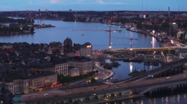 Rıhtımda makineli inşaat alanının hava görüntüleri. Gün batımında şehirde vinçler ve şehir gelişimi. Stockholm, İsveç.