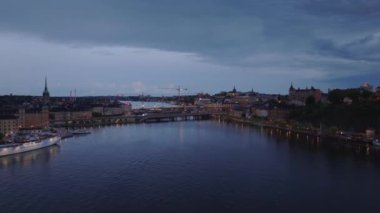 Şehirdeki köprülerin ve inşaat alanındaki vinçlerin havadan görüntüsü. Akşamları su üstünde uçuyorum. Stockholm, İsveç.