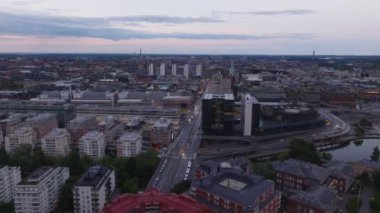 Alacakaranlıktaki şehir manzarası. Ana tren istasyonu ve ulaşım terminali çevresindeki yollarda trafik vardı. Stockholm, İsveç.