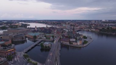 Kvarteret Luna ve Riddarholmen adasında turistik yerler. Alacakaranlıkta tarihi şehir merkezine giden çok şeritli yolun hava manzarası. Stockholm, İsveç.