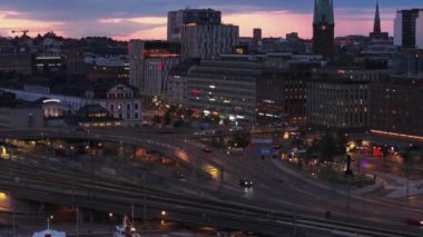 Alacakaranlıkta şehrin çok katlı kavşağından geçen araçların Arial kaydırak ve pan görüntüleri. Stockholm, İsveç.